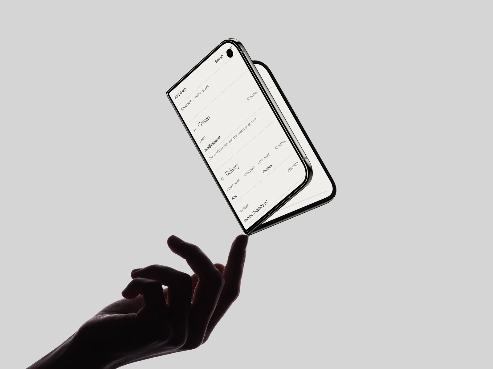A phone caught mid air above an open hand, showing the Aplomb checkout contact and delivery form