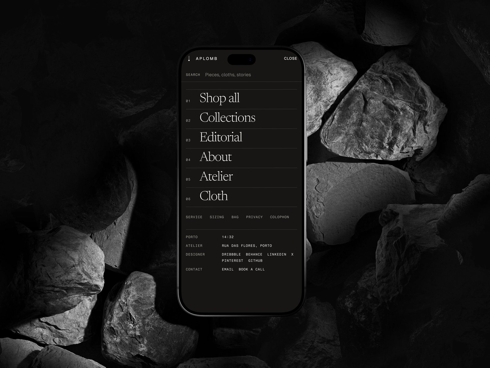 The Aplomb navigation overlay in its dark Wool mode on a phone lying among grey stones